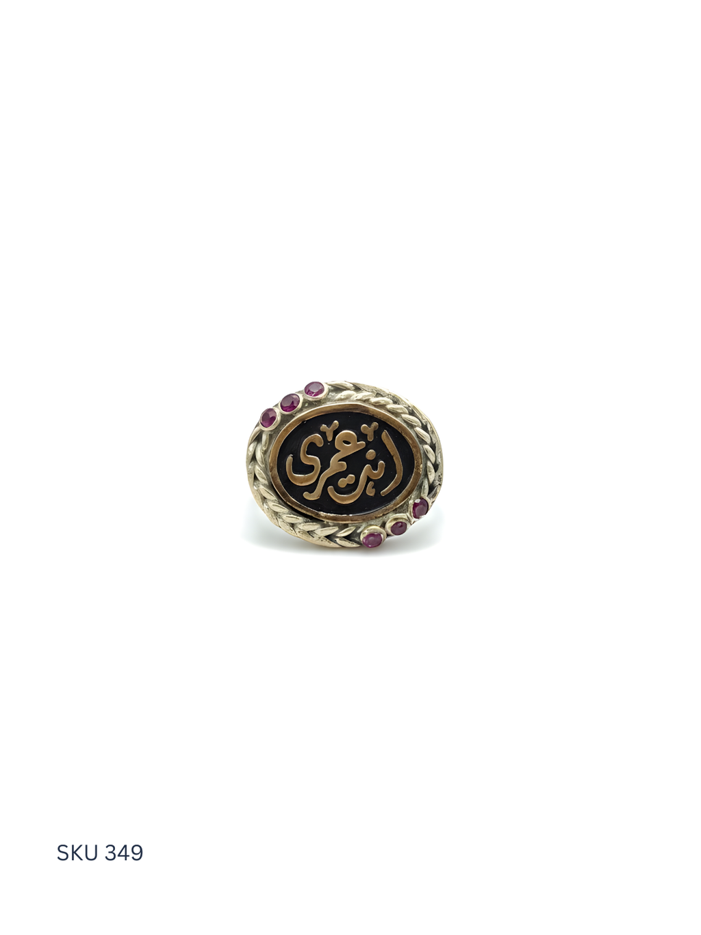 Decorative ring with Arabic calligraphy and gemstones on a white background