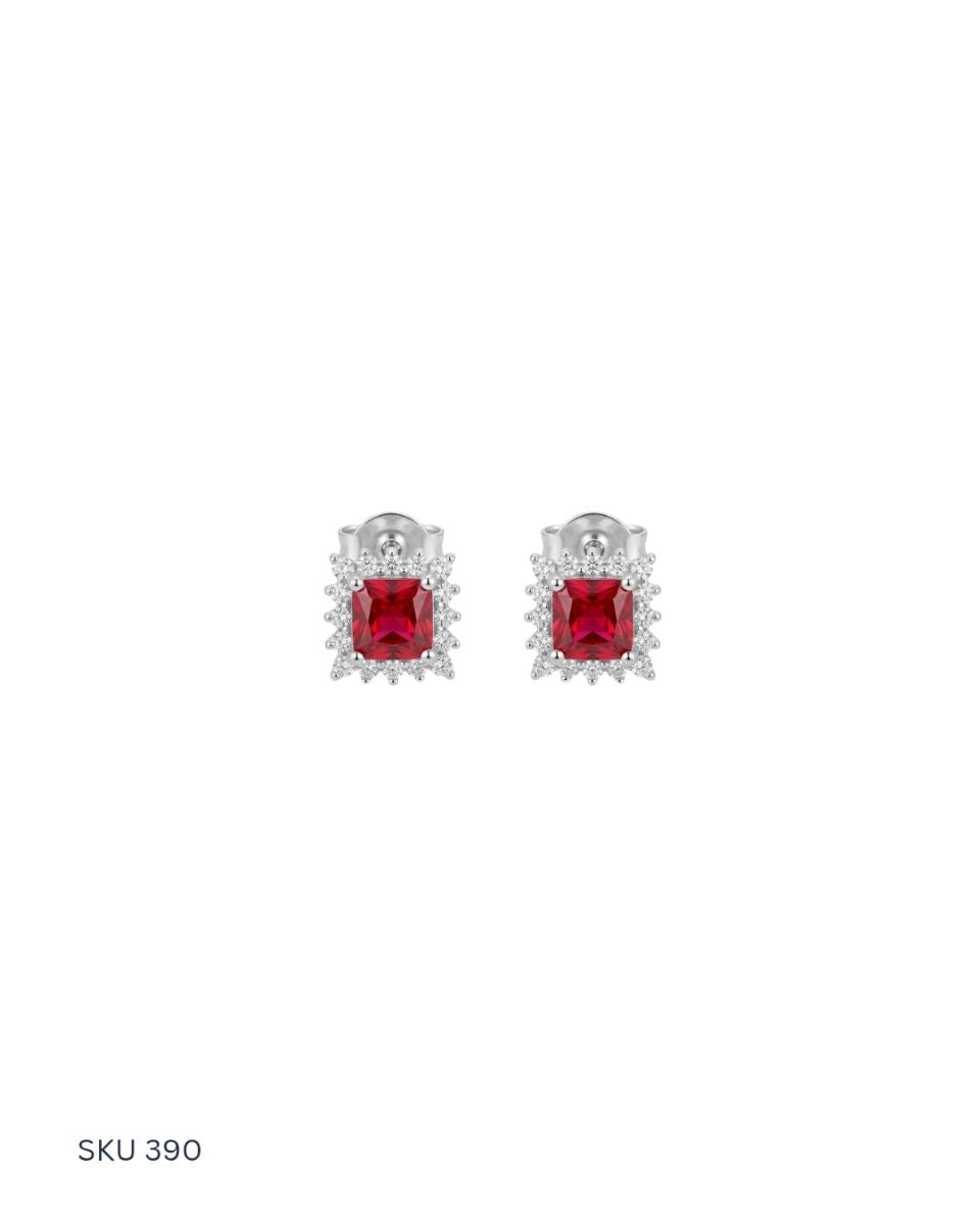 Pair of earrings with red gemstones on a white background