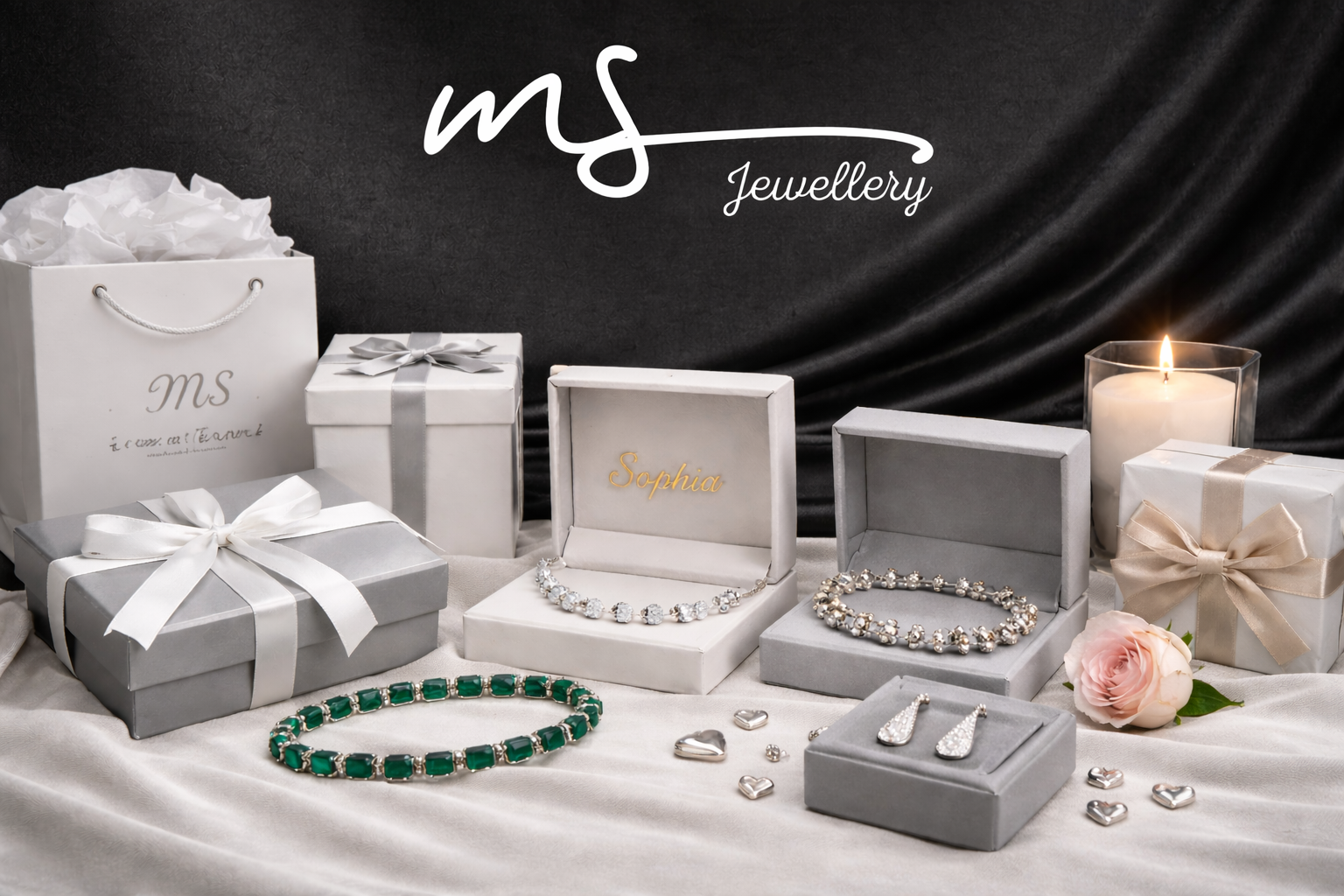 MS Jewellery display with jewelry boxes, bracelets, and earrings on a dark background.
